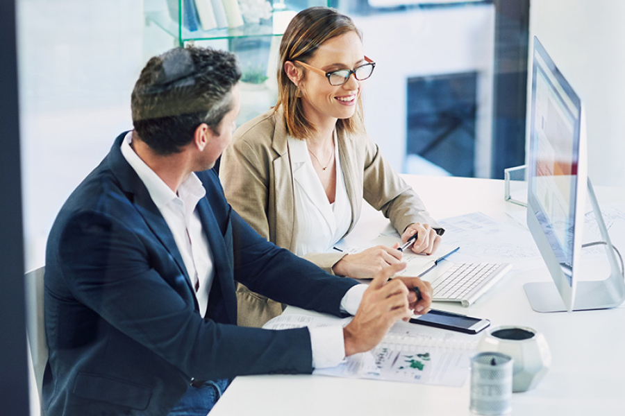 Business professionals analyzing report on computer