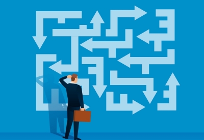 Businessman looking at the labyrinth of arrows looking for the right direction