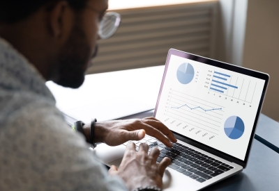 Consultant using laptop with benchmarking graphs on the screen
