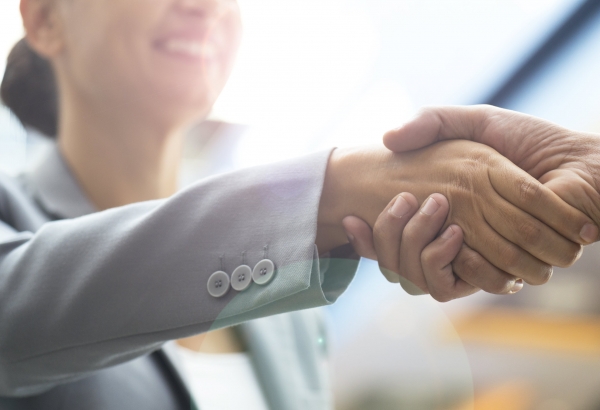 Two business people shaking hands and smiling