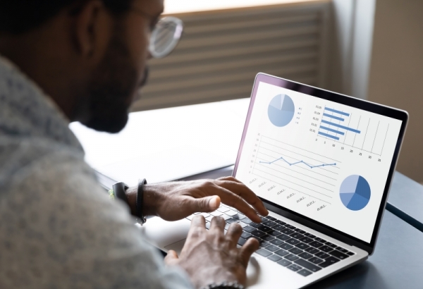 Consultant using laptop with benchmarking graphs on the screen